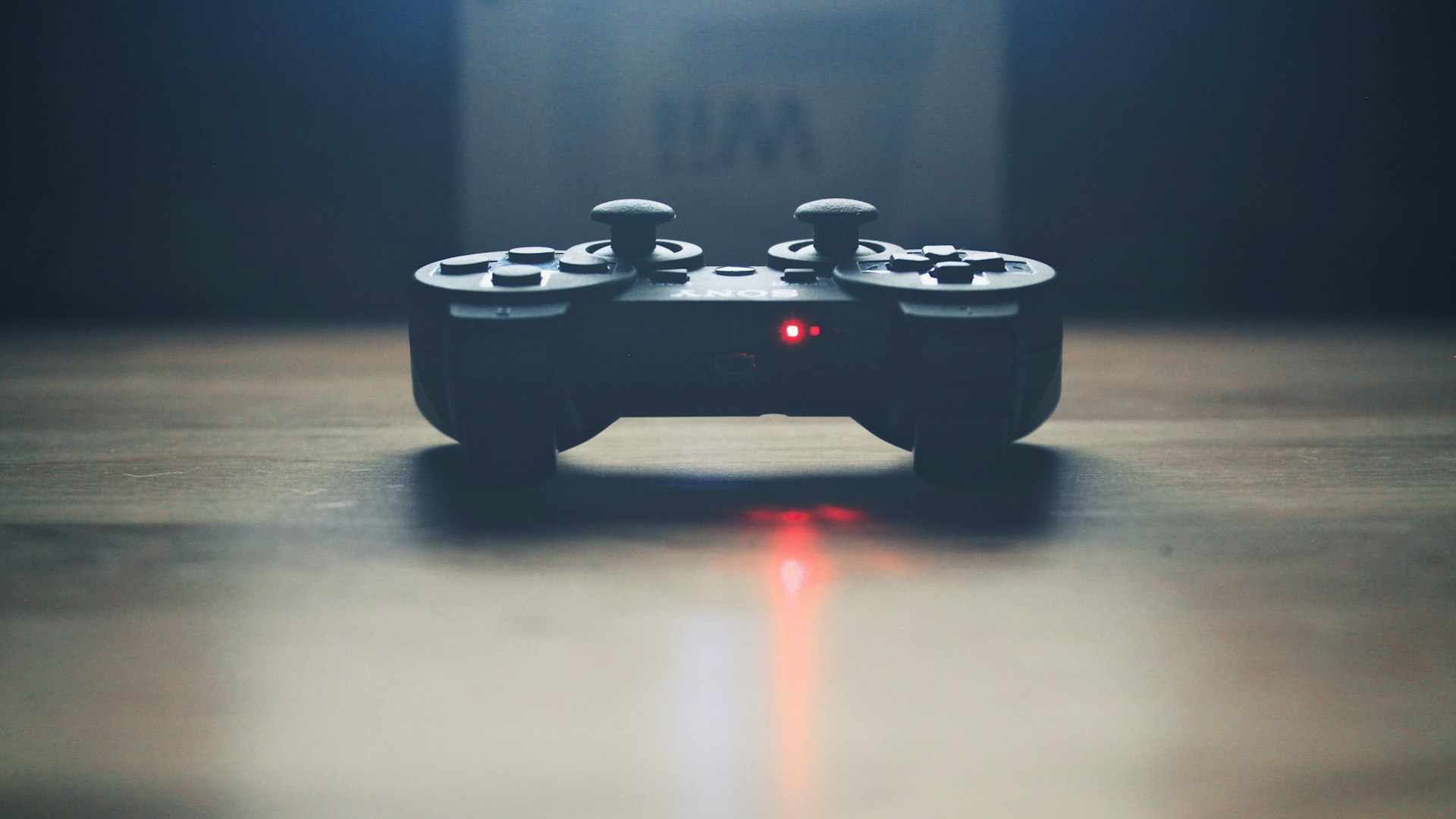 A quiet desk lit by a warm lamp, controller resting beside an open notebook